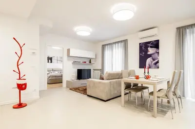 a white living room with a table and a couch at Fior Apartments in Merano