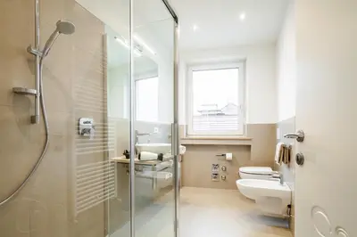 a bathroom with a shower and a toilet and a sink at Fior Apartments in Merano