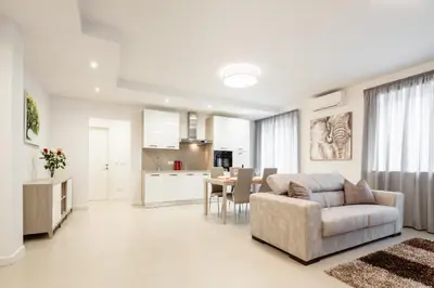 a living room and kitchen with a couch and a table at Fior Apartments in Merano