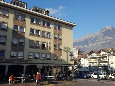 a building in a city with a mountain in the background at Fior Apartments in Merano