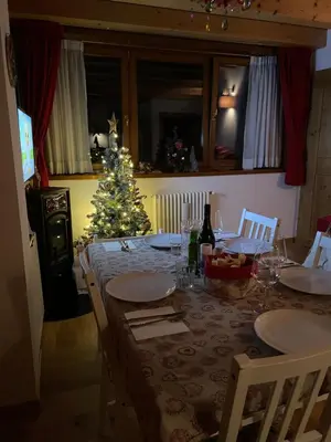 a dining table with a christmas tree in a room at Casa Romeo in San Vito di Cadore