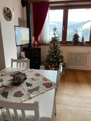 a living room with a christmas tree and a table at Casa Romeo in San Vito di Cadore