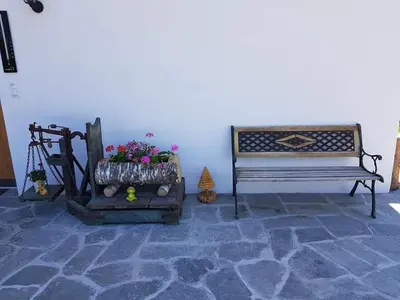 a room with a bench and flowers on a stone floor at Ferienwohnungen Schlosshäusl in San Lorenzo di Sebato