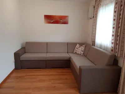 a gray couch in a living room with a window at Ferienwohnungen Schlosshäusl in San Lorenzo di Sebato