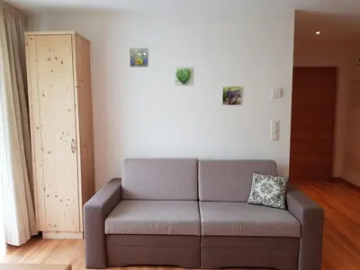 a living room with a couch and a cabinet at Ferienwohnungen Schlosshäusl in San Lorenzo di Sebato