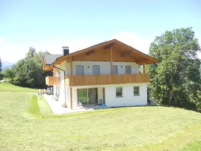 a house on a hill with a large yard at Ferienwohnungen Schlosshäusl in San Lorenzo di Sebato