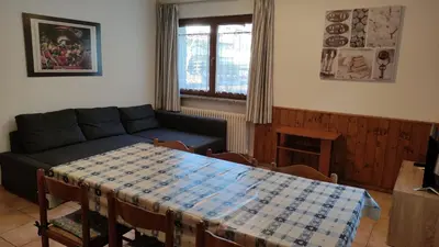 a living room with a table and a couch at Cesa Stefi in Canazei