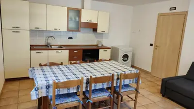 a kitchen with a table with chairs and a sink at Cesa Stefi in Canazei