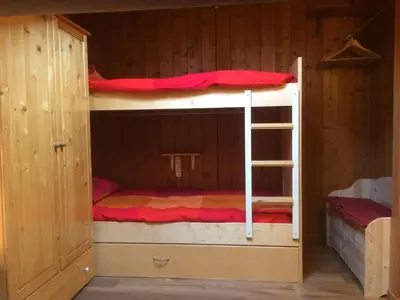 a bunk bed with a ladder in a cabin at Appartamento Esprit Des Alpes in Canazei
