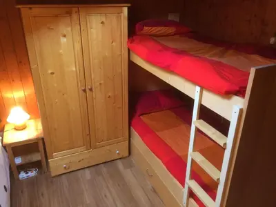 a small room with a bunk bed and a closet at Appartamento Esprit Des Alpes in Canazei