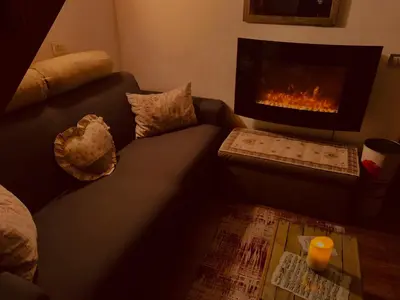a living room with a couch and a fireplace at Appartamento Esprit Des Alpes in Canazei
