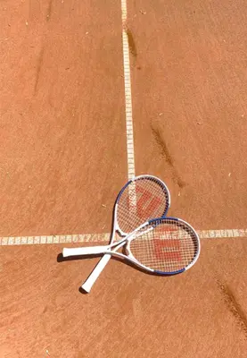 a tennis racket laying on a tennis court at Villa Maier B&B & Apartments in Soprabolzano