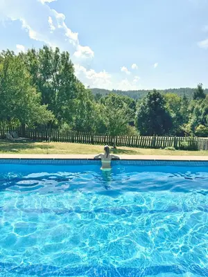 a person is sitting in a swimming pool at Villa Maier B&B & Apartments in Soprabolzano