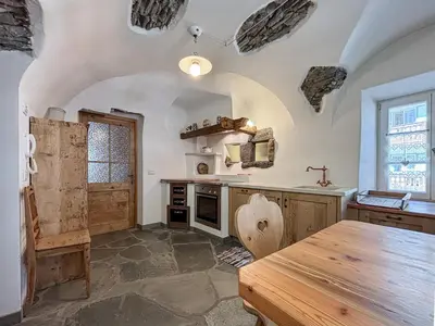 a kitchen with a wooden table in a room at Apartment Dolavilla in Canazei