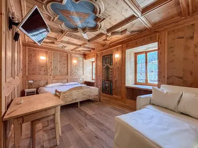 a bedroom with two beds and a table in a room at Apartment Dolavilla in Canazei