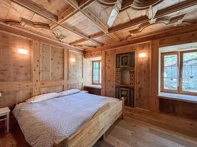 a bedroom with a bed in a room with wooden walls at Apartment Dolavilla in Canazei