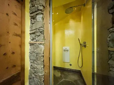 a bathroom with a shower with a yellow wall at Apartment Dolavilla in Canazei