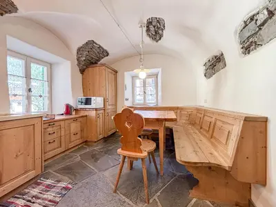 a kitchen with wooden cabinets and a wooden table at Apartment Dolavilla in Canazei