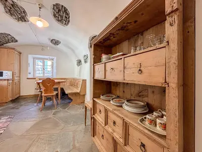 a kitchen with wooden cabinets and a table at Apartment Dolavilla in Canazei