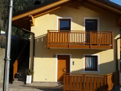 a house with a balcony and a staircase at Casa Alice 5.5 in Fiera di Primiero