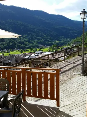 a wooden deck with a table and a street light at Casa Alice 5.5 in Fiera di Primiero