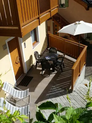 an outdoor patio with a table and an umbrella at Casa Alice 5.5 in Fiera di Primiero