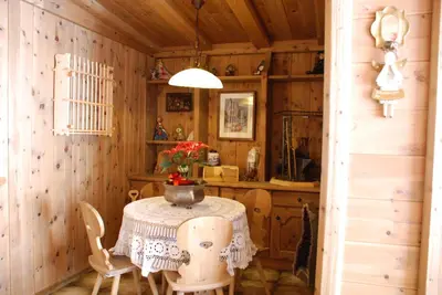 a dining room with a table and chairs in a cabin at Garni Cristallo in San Vigilio Di Marebbe