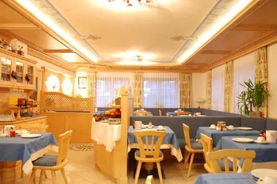 a restaurant with blue tables and chairs in a room at Garni Cristallo in San Vigilio Di Marebbe