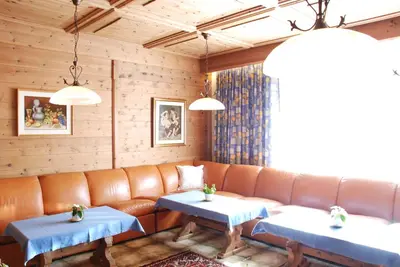a living room with a couch and two tables at Garni Cristallo in San Vigilio Di Marebbe