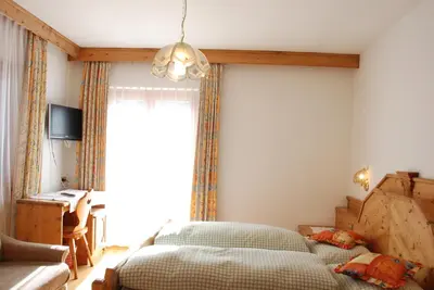 a bedroom with a bed and a window at Garni Cristallo in San Vigilio Di Marebbe