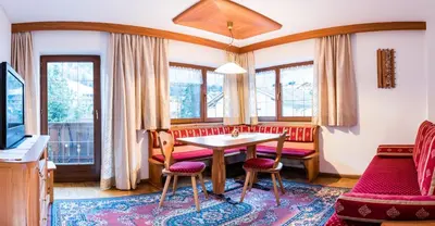 a living room with a table and chairs at Apartments Elise in Selva di Val Gardena