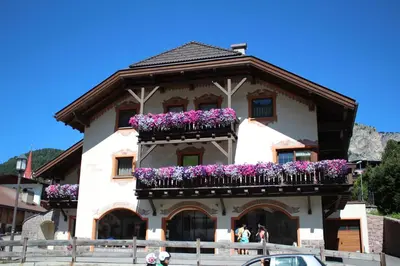 a building with flowers on a balcony at Apartments Elise in Selva di Val Gardena