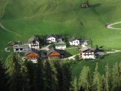 a group of houses on a green hill at Lüch da Spescia in La Valle
