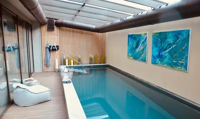 a swimming pool in a room with at The Lodge Sporthotel - Golfclub Eppan in Appiano sulla Strada del Vino