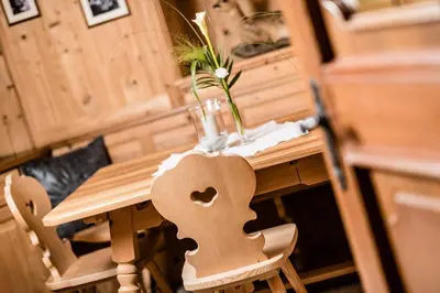 a wooden table with a vase of flowers on it at Nutzhof - Mediterran Flair Hotel in Lagundo