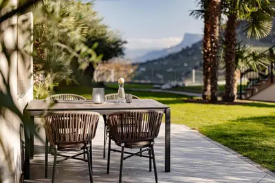 a table with two chairs and a bottle of wine at Nutzhof - Mediterran Flair Hotel in Lagundo