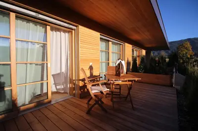 a wooden deck with a table and chairs on it at Apartments Im Winkl in Brunico