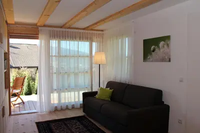 a living room with a couch and a large window at Apartments Im Winkl in Brunico
