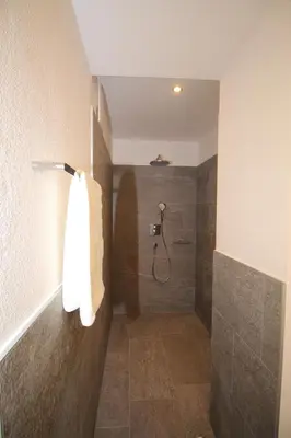 a bathroom with a shower with a towel on a wall at Apartments Im Winkl in Brunico
