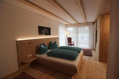 a bedroom with a bed with green pillows and a window at Apartments Im Winkl in Brunico