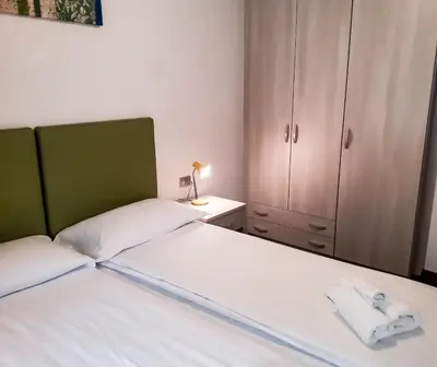 a bedroom with a bed and a cupboard with a towel at Sas da Rocia by go new location in Soraga