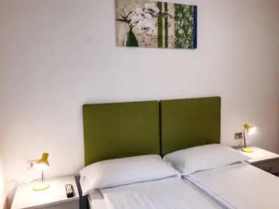 a bed with a green headboard in a room at Sas da Rocia by go new location in Soraga