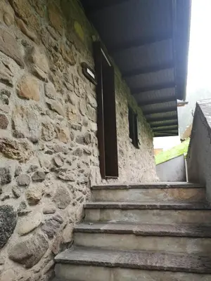 a stone building with stairs and a window at Sas da Rocia by go new location in Soraga