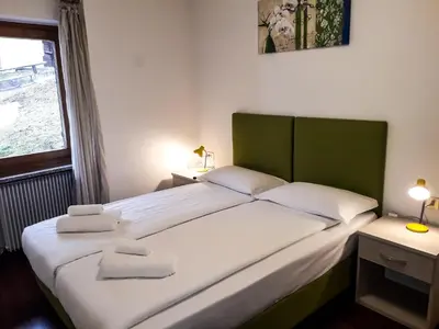 a bedroom with a large bed with two pillows on it at Sas da Rocia by go new location in Soraga