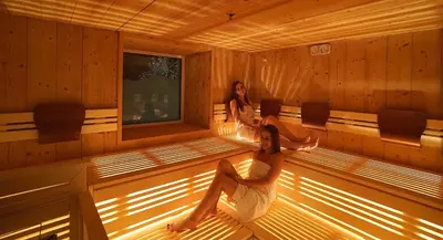 two women are sitting in a sauna at Hotel Oberwirt in Verano