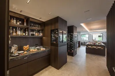 a large kitchen with a bar and a wine cellar at Hotel Oberwirt in Verano