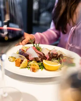 a plate of food with meat and vegetables on a table at Hotel Oberwirt in Verano