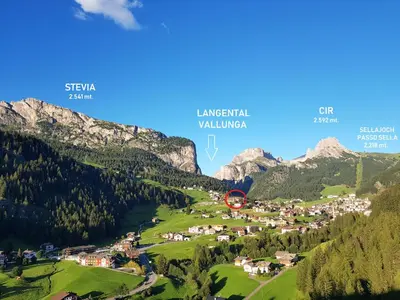 a village in a valley in the mountains at Appartamento Dolomiti in Selva di Val Gardena