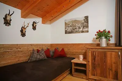 a couch in a room with antlers on the wall at Berg-Weiler-Obereggerhof in Schenna