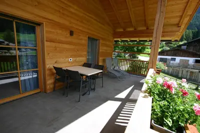 a patio with a table and chairs on a deck at Hilpoldhof in Castelrotto